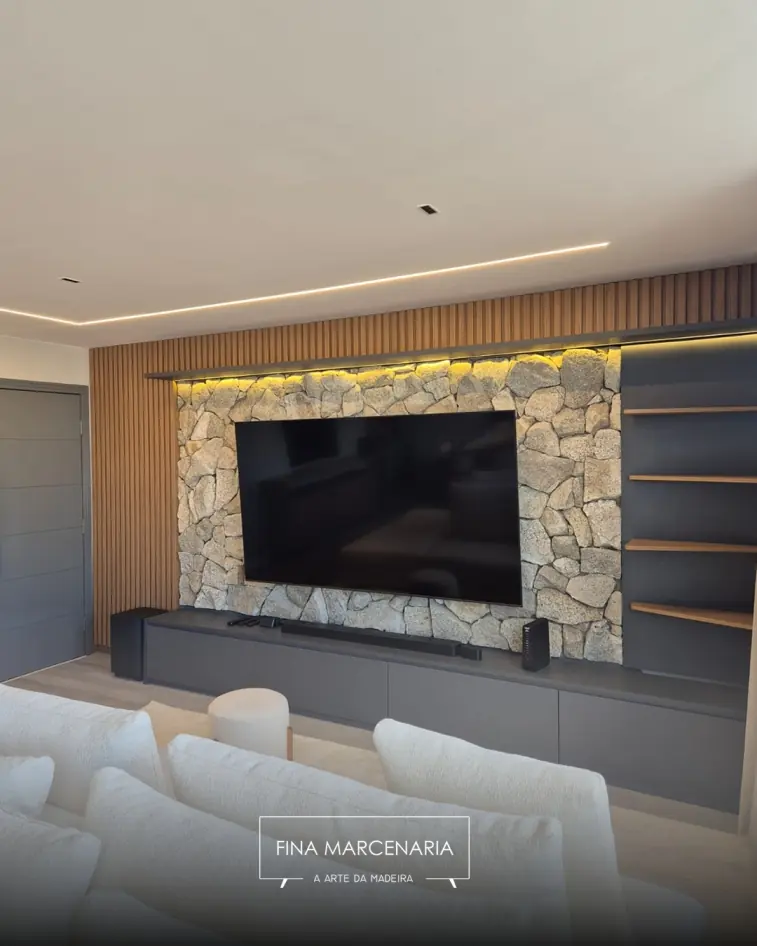 Painel de TV com parede de pedra e iluminação embutida