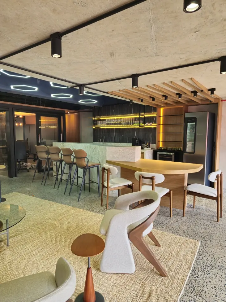 Lounge do camarote com bancada, ripado de madeira e teto de concreto
