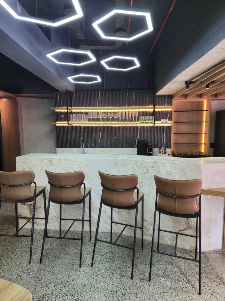 Estrutura metálica preta com prateleiras e iluminação em área de lounge